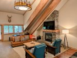 Cozy living room with gas fireplace, comfortable seating, and beautiful exposed wood beams